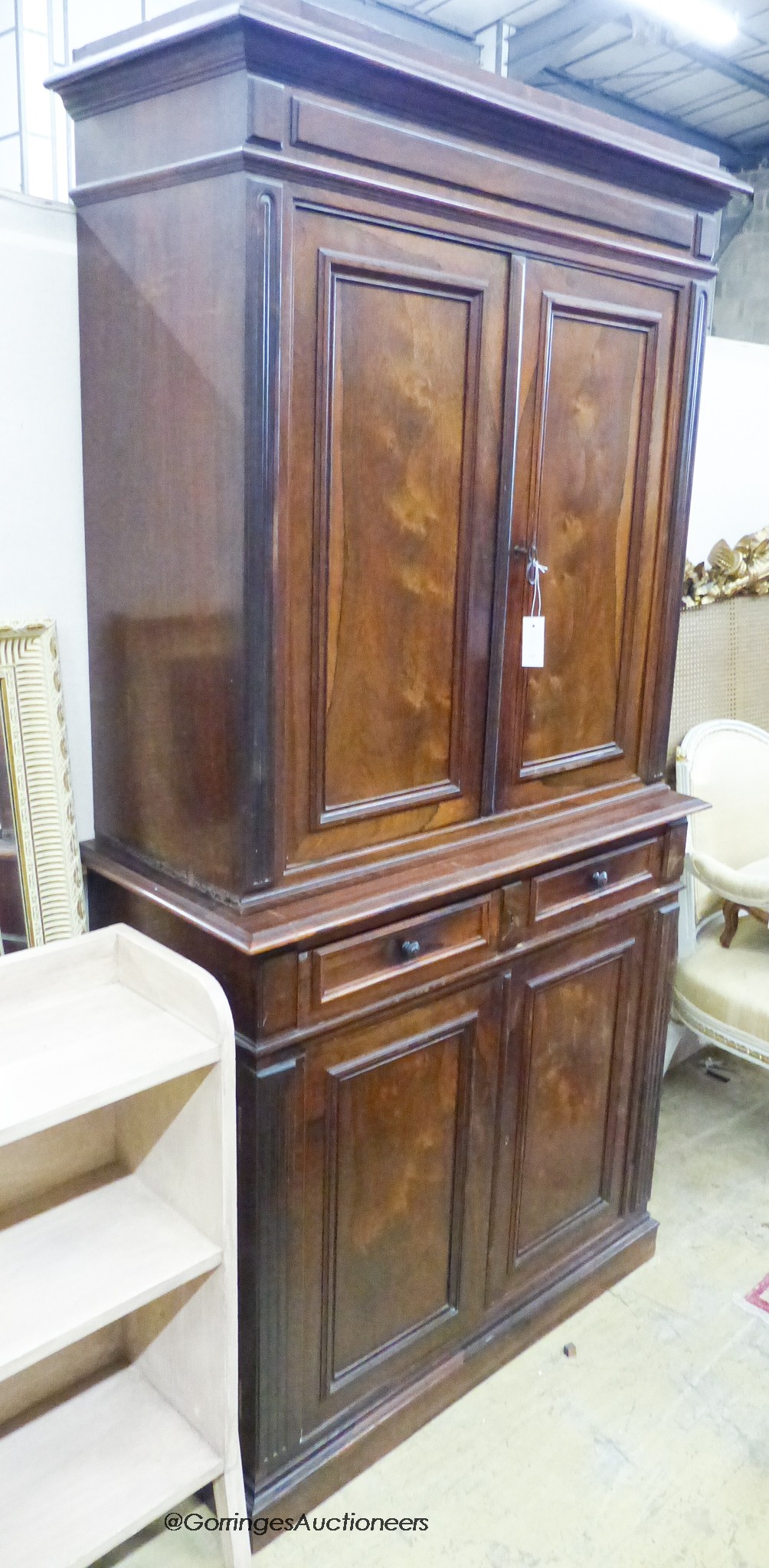 A late 19th century French rosewood two part cupboard wih two drawers and panelled doors